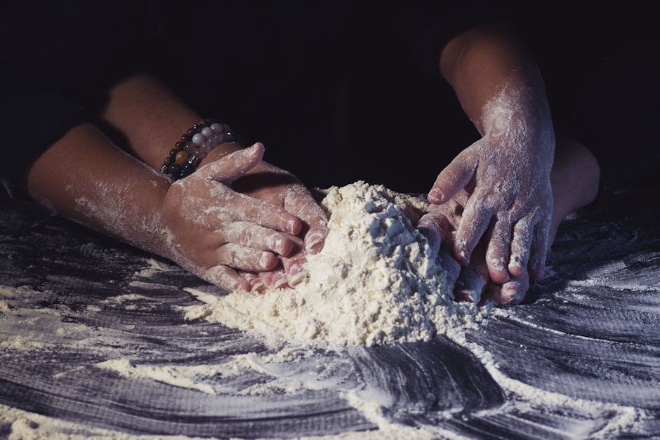 Mains travaillant de la farine sur un plan de travail
