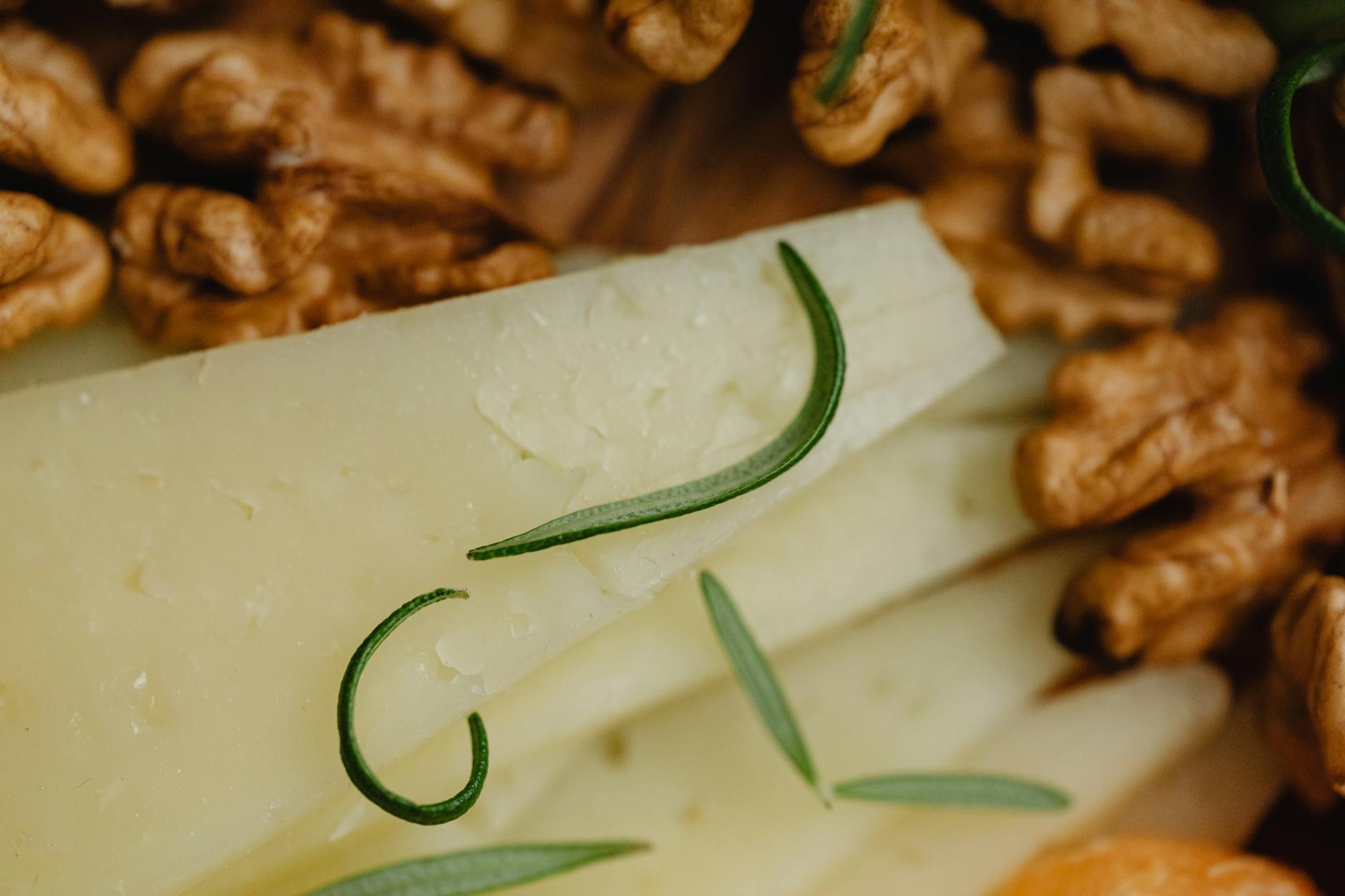 Pain de seigle aux noix sur une planche en bois avec couteau et fromages