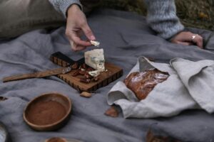 Pain de seigle aux noix sur une planche en bois avec couteau et fromages
